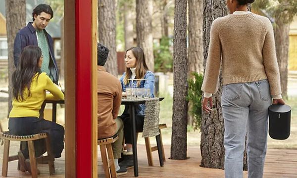 Kvinne som bærer Sonos Move forbi en forttauskafe