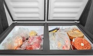 En åpen fryseboks med frysevarer inni