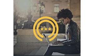 Kvinne som sitter med en bærbar datamaskin og et gult passordsymbol over 