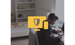 Gutt ved skrivebord som bruker bærbar datamaskin og et gult datasympol med Nortonlogo over