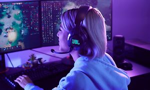 Jente som bruker et JBL Quantum-headset og spiller DOTA