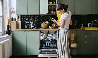 mann og kvinne foran åpen oppvaskmaskin