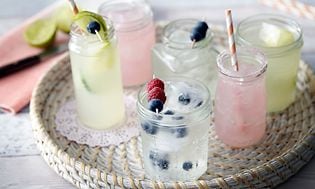 Glass med vann, saft, isbiter og blåbær