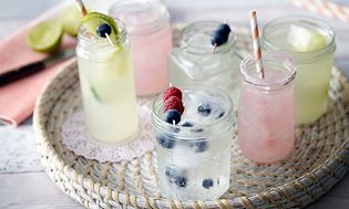 Glass med vann, saft, isbiter og blåbær