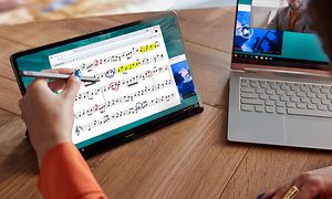 En Lenovo P12 Pro ved siden av en bærbar PC