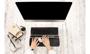 Person som bruker et Contour-tastatur og RollerMouse Red