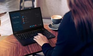 Woman sitting at a cafe using Lenovo ThinkPad laptop