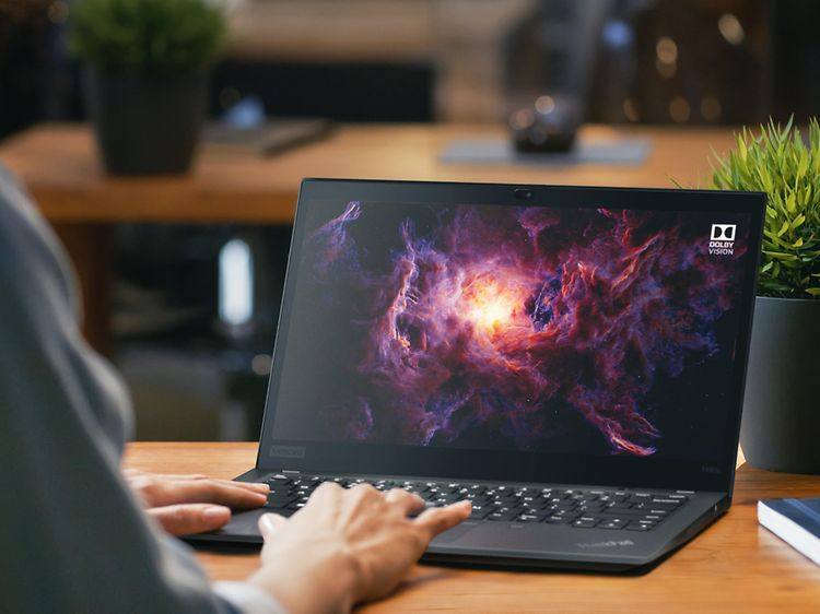 Person sitting in office using Lenovo ThinkPad laptop