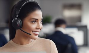 Kvinne med sorte Evolve2 65-hodetelefoner på kontor