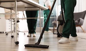 Person som støvsuger gulvet på et kontor