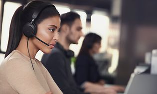 Kvinne med Jabra Evolve2 40 på kontor med kolleger