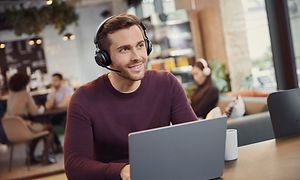 Mann med Jabra Evolve2 65 på kafe