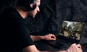 mann sitter foran en bærbar gaming-pc