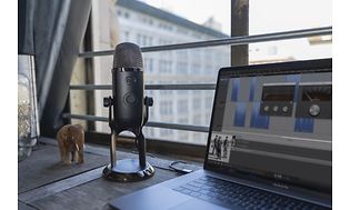 Yeti X-mikrofon på et skrivebord med en bærbar pc