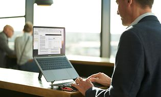 Mann i dress jobber på en bærbar PC med Contour tastatur