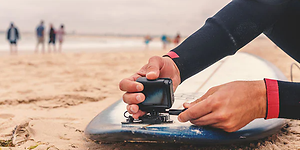 Surfebrett med actionkamera på stranden