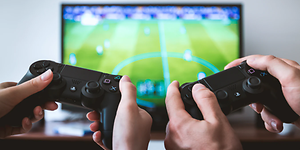Nærbilde av PS4 kontroller mens de spiller FIFA