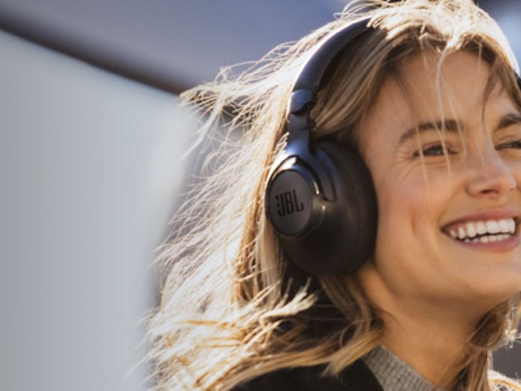 Kvinne med JBL ANC-hodetelefoner