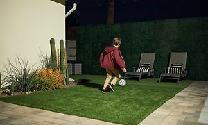 Arlo - Kid playing football under the lights in garden