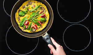 Stekepanne ovenfra med omelett oppi på en stekeovn