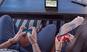 Nintendo Switch - to personer spiller med joycon-kontroller på enhet på bord