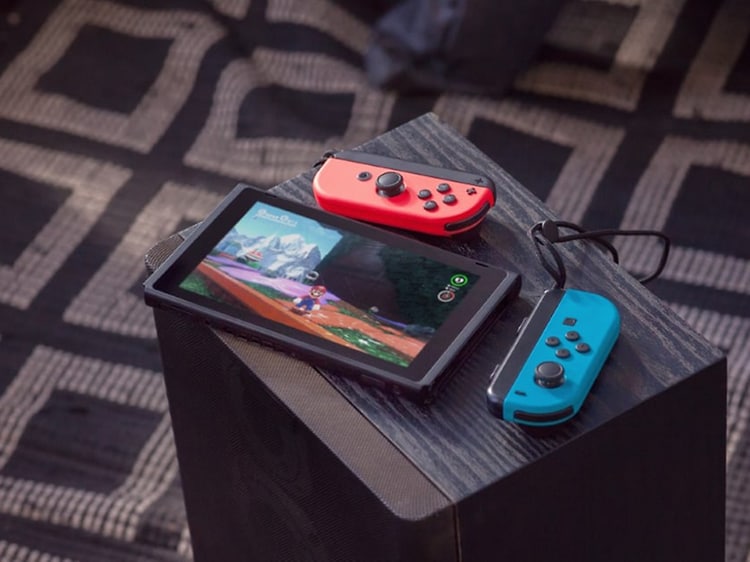 Nintendo Switch med to joycon-kontroller liggende på en høyttaler