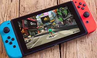 Nintendo Switch spillkonsoll ligger på tregulv