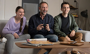 Nintendo Switch - mann og to barn gamer sammen i en sofa