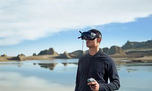 Mann med VR-briller som flyr DJI FPV med motion controlleren