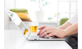 skriver på bærbar PC i et lyst rom