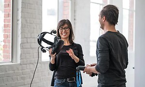 Kvinne holder og forklarer VR mens hun holder VR-briller