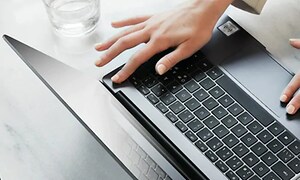 Person bruker fingeravtrykk for å låse opp en PC