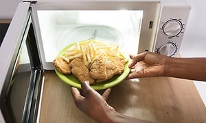 pommes frittes og kyllingnuggets settes i mikrobølgeovn