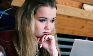 jente sitter foran bærbar pc