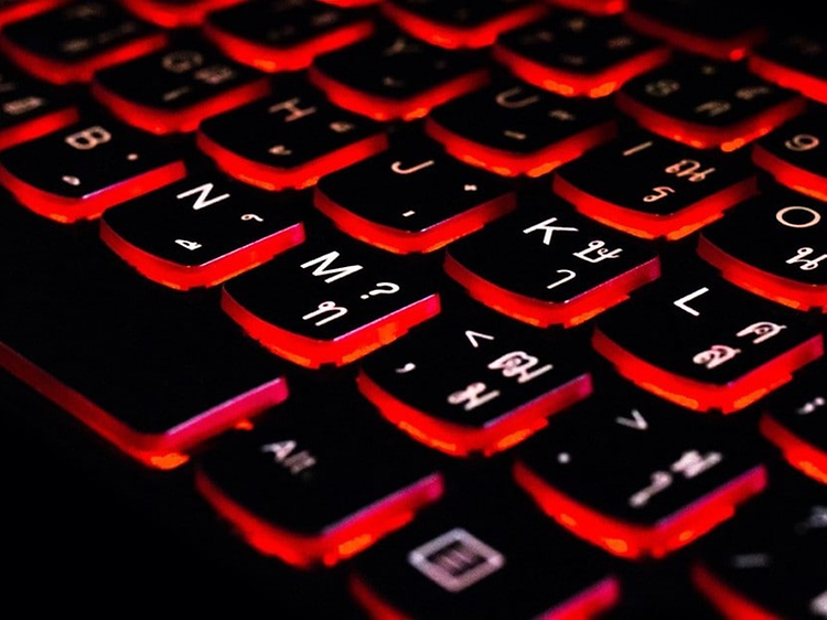 detaljbilde av et svart tastatur med rød bakgrunnsbelysning