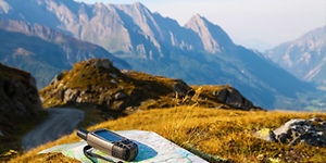 GPS liggende på et kart foran et stort fjellandskap