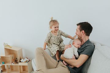 En far som sitter i en sofa med hans to barn