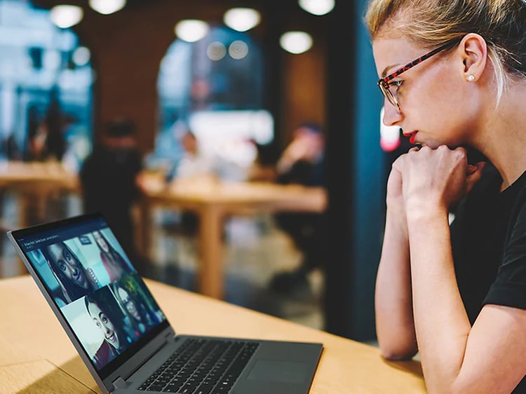 Kvinne har videomøte på kafé med en Lenovo Flex 5 laptop