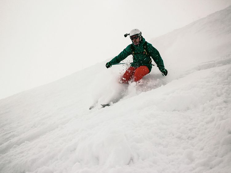 Mann står på ski med GoPro og hjelm