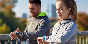 Workout couple adjusting their smartwatches
