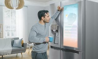 mann ser på en skjerm på sitt smart kjøleskap