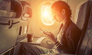 Kvinne i flysete som bruker smarttelefon