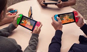 Barn som spiller Nintendo Switch rundt et bord