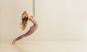 Kvinne som gjør yoga i en tøyslynge