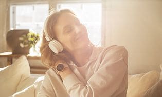 En kvinne med hodetelefoner som hører på musikk fra sin Polar Ignite 2