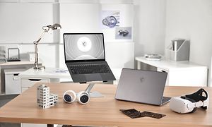To MSI Creator Z16P på et skrivebord, en lukket og en åpen som viser skjem