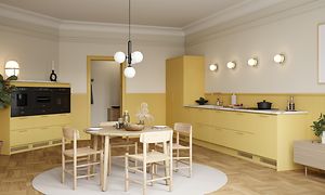 Yellow Epoq Trend Mellow-kjøkken, med benkeplate i marmorlaminat, integrert stekeovn og kaffetrakter, spisebord og stoler.