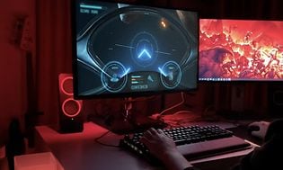 Datamaskin som viser bilspill i et rom med rødt mykt lys
