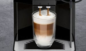 Siemens kaffemaskin heller kaffe i et glass med kaffe og melkeskum