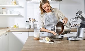 En kvinne på et kjøkken baker med en Kenwood Chef XL Elite kjøkkenmaskin